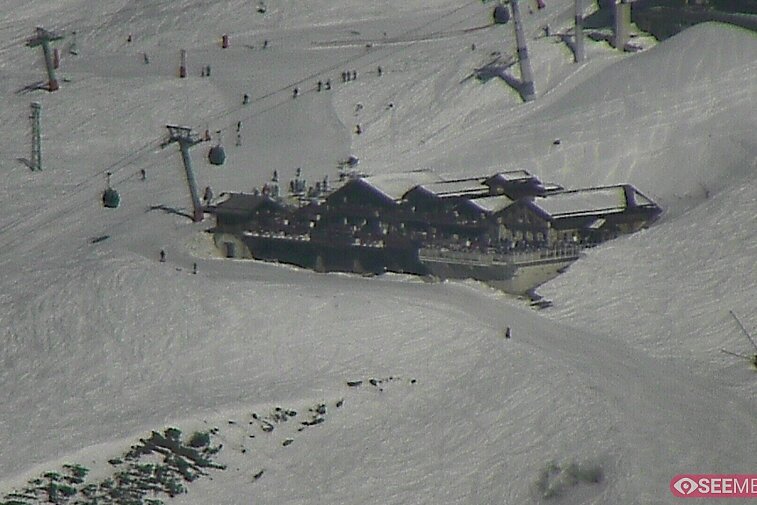 Webcam view of the Folie Douce mountain restaurant in Meribel.  In the background are the Biche (blue) and Maudit (red) pistes; and the pictured lift/mid-station is the Saulire Express.