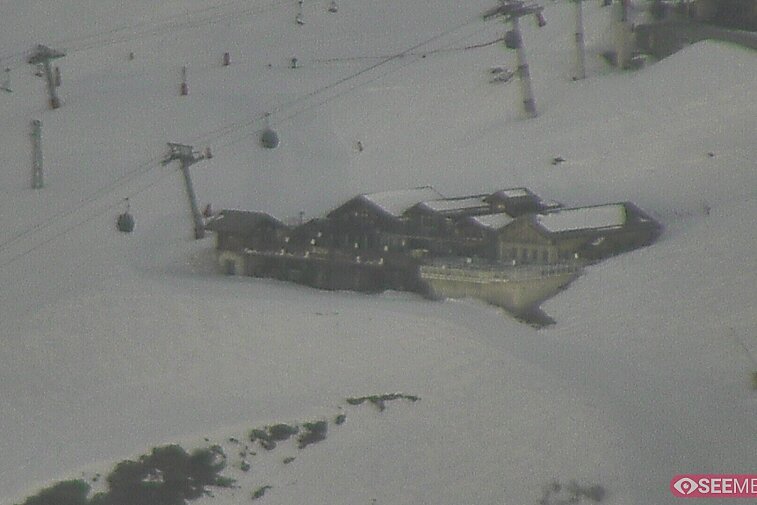 Webcam view of the Folie Douce mountain restaurant in Meribel.  In the background are the Biche (blue) and Maudit (red) pistes; and the pictured lift/mid-station is the Saulire Express.