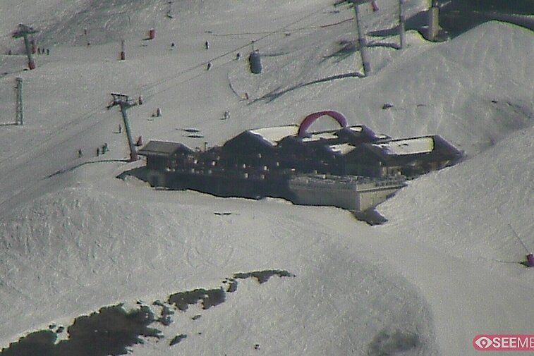 Webcam view of the Folie Douce mountain restaurant in Meribel.  In the background are the Biche (blue) and Maudit (red) pistes; and the pictured lift/mid-station is the Saulire Express.
