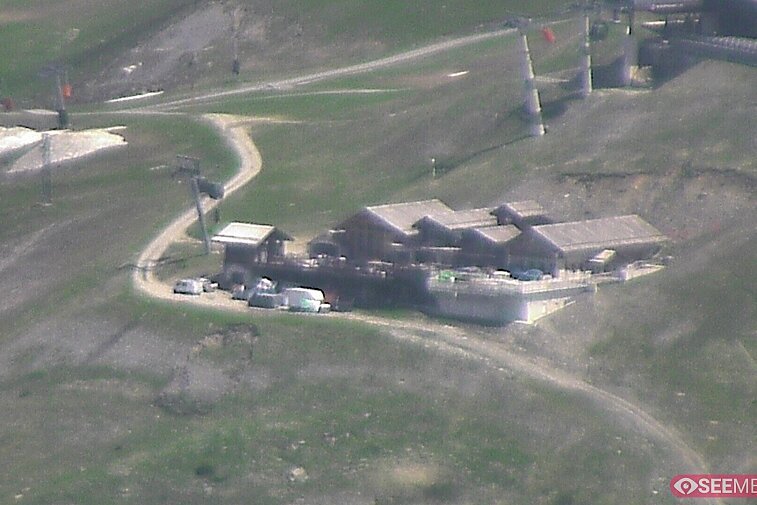 Webcam view of the Folie Douce mountain restaurant in Meribel.  In the background are the Biche (blue) and Maudit (red) pistes; and the pictured lift/mid-station is the Saulire Express.