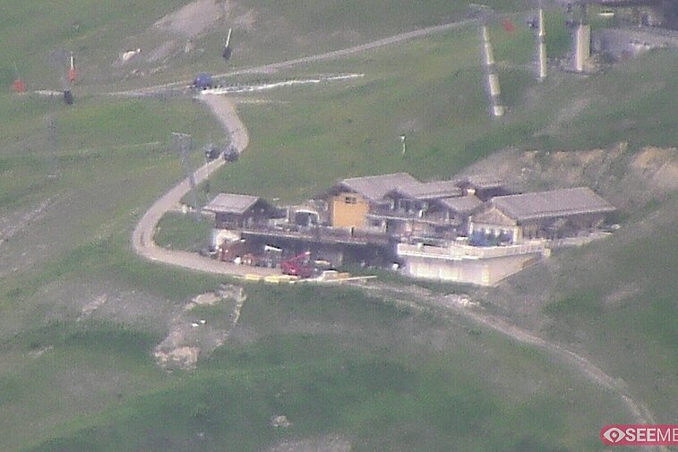 Webcam view of the Folie Douce mountain restaurant in Meribel.  In the background are the Biche (blue) and Maudit (red) pistes; and the pictured lift/mid-station is the Saulire Express.