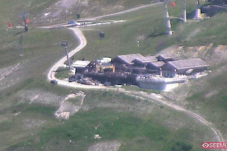 Webcam view of the Folie Douce mountain restaurant in Meribel.  In the background are the Biche (blue) and Maudit (red) pistes; and the pictured lift/mid-station is the Saulire Express.