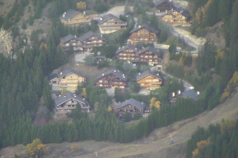 an image of mountain road with chalets